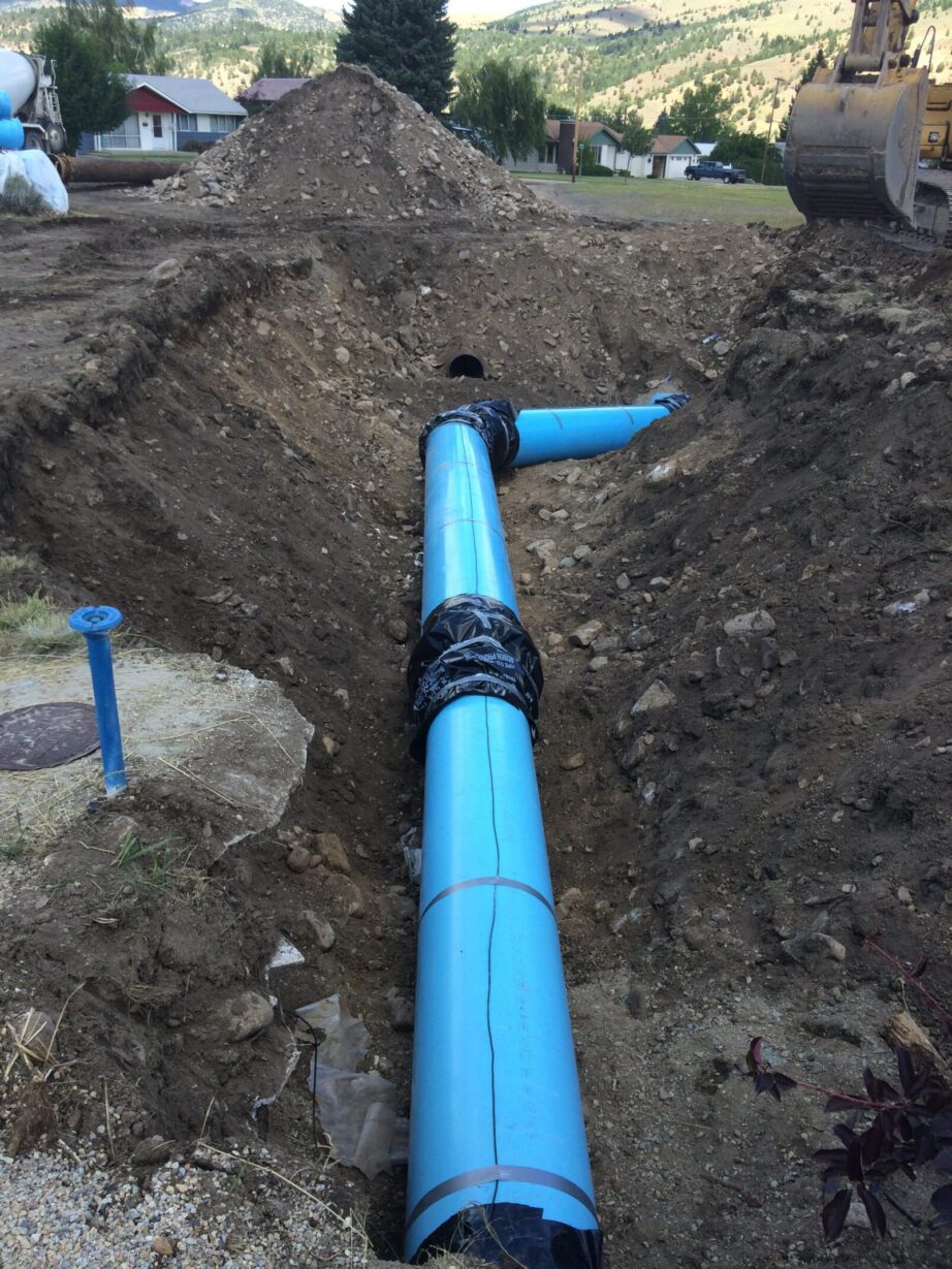Blue pipeline installation in construction site.
